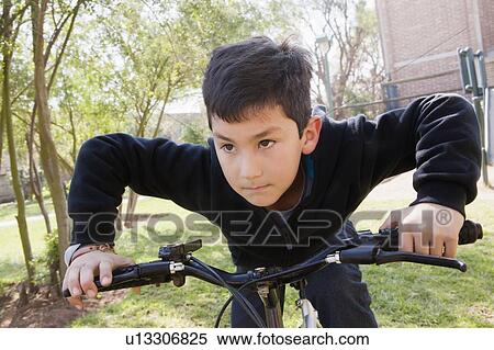Boy riding bicycle in park View Large Photo Image Stock Photography - Boy riding bicycle in park. Fotosearch
