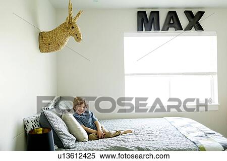 Stock Photography - Boy sitting on his bed. Fotosearch