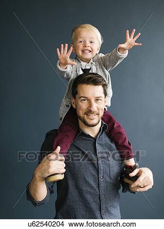 Picture - Boy sitting on his father's shoulders. Fotosearch