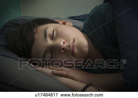 Stock Photo - Boy sleeping in bed. Fotosearch