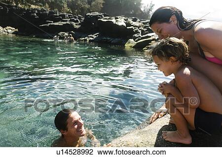 Stock Image - Boy with his parents by tide pool. Fotosearch