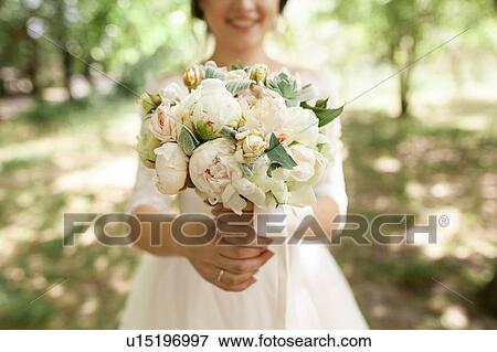 Bride holding bouquet of roses View Large Photo Image Stock Photo - Bride holding bouquet of roses. Fotosearch