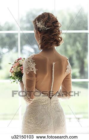 Bride with bouquet by window View Large Photo Image Stock Image - Bride with bouquet by window. Fotosearch