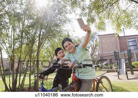 Brothers taking selfie on bicycles View Large Photo Image Stock Photograph - Brothers taking selfie on bicycles. Fotosearch