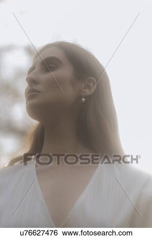 Stock Photograph - Brown haired young woman looking away. Fotosearch