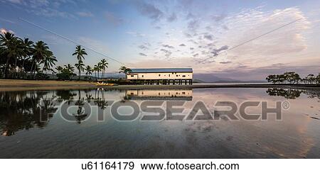 Stock Photo - Building by beach at sunset in Port Douglas, Australia. Fotosearch