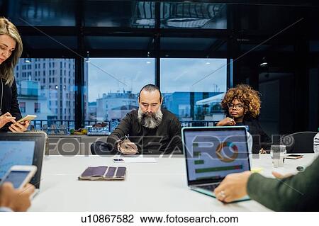 Stock Image - Business partners at brainstorming meeting in office. Fotosearch
