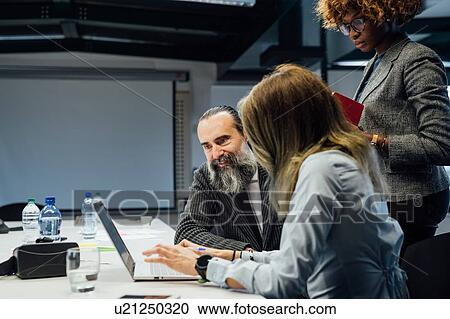 Stock Image - Business partners at brainstorming meeting in office. Fotosearch