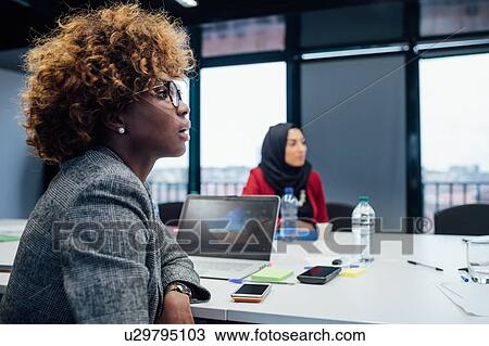 Stock Image - Business partners at brainstorming meeting in office. Fotosearch