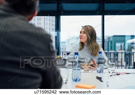 Stock Image - Business partners at brainstorming meeting in office. Fotosearch