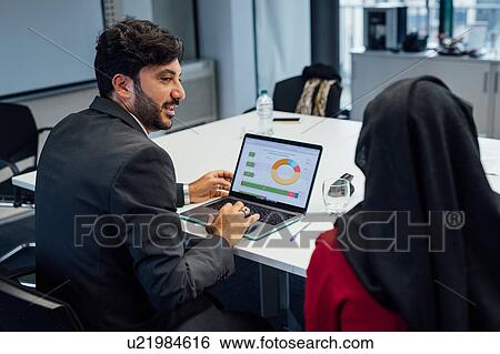 Stock Photograph - Business partners at brainstorming meeting in office. Fotosearch