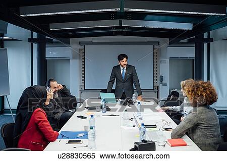 Stock Photography - Business partners at brainstorming meeting in office. Fotosearch