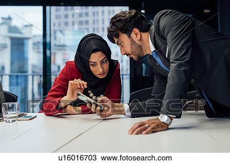 Stock Image - Business partners at meeting in office. Fotosearch