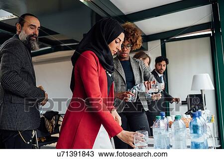 Business partners having tea break in office View Large Photo Image Stock Image - Business partners having tea break in office. Fotosearch
