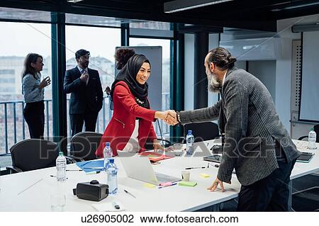 Business partners shaking hands at meeting in office View Large Photo Image Stock Image - Business partners shaking hands at meeting in office. Fotosearch