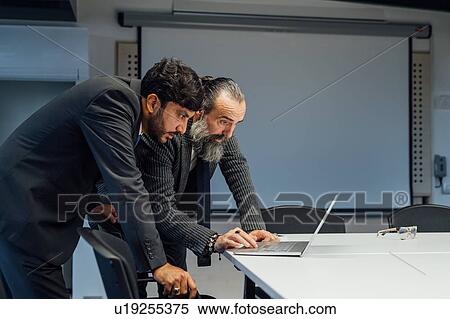 Business partners using laptop in office View Large Photo Image Stock Photography - Business partners using laptop in office. Fotosearch