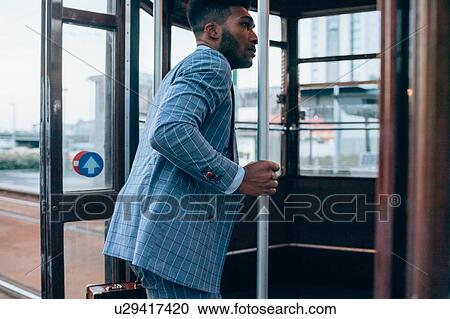 Businessman boarding tram in city View Large Photo Image Stock Image - Businessman boarding tram in city. Fotosearch
