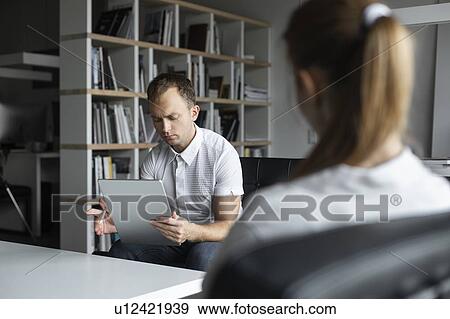 Businessman conducting job interview with young woman View Large Photo Image Stock Photo - Businessman conducting job interview with young woman. Fotosearch