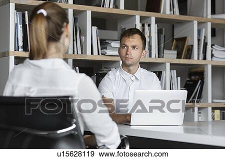 Businessman conducting job interview with young woman View Large Photo Image Stock Photo - Businessman conducting job interview with young woman. Fotosearch