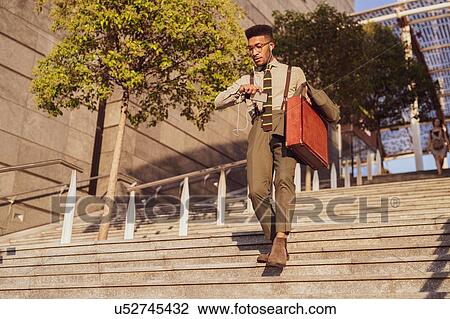 Stock Image - Businessman descending stairs of office building, Milano, Lombardia, Italy. Fotosearch