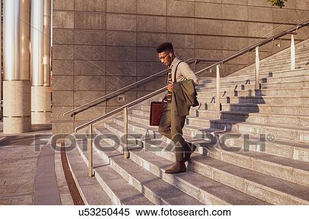 Stock Photography - Businessman descending stairs of office building, Milano, Lombardia, Italy. Fotosearch