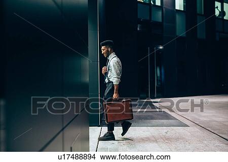 Picture - Businessman entering office building, Milano, Lombardia, Italy. Fotosearch