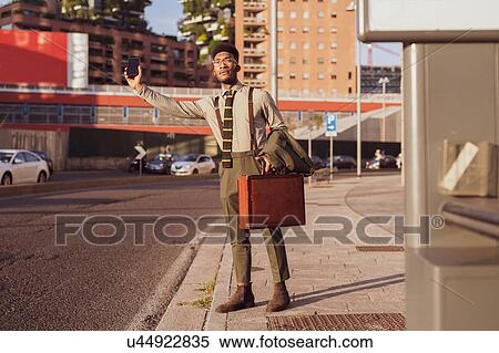 Businessman hailing transport on pavement, Milano, Lombardia, Italy View Large Photo Image Stock Photography - Businessman hailing transport on pavement, Milano, Lombardia, Italy. Fotosearch
