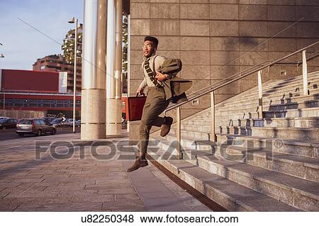 Stock Photo - Businessman jumping off stairs of office building, Milano, Lombardia, Italy. Fotosearch