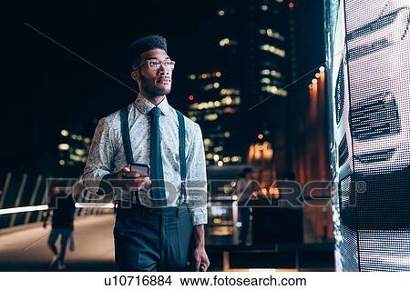 Picture - Businessman looking at digital information board, Milano, Lombardia, Italy. Fotosearch