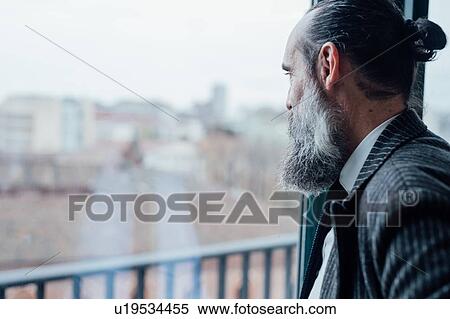 Stock Photography - Businessman looking out of window. Fotosearch