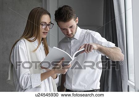 Businessman pointing to page in book for colleague View Large Photo Image Stock Image - Businessman pointing to page in book for colleague. Fotosearch