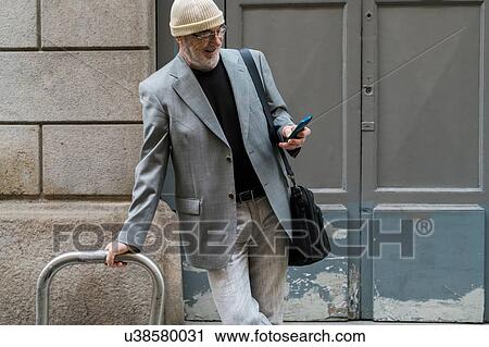 Businessman resting against bicycle frame using smartphone, Milan, Lombardia, Italy View Large Photo Image Stock Image - Businessman resting against bicycle frame using smartphone, Milan, Lombardia, Italy. Fotosearch