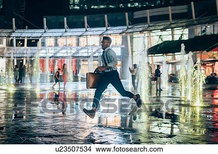 Businessman running across square, Milano, Lombardia, Italy View Large Photo Image Picture - Businessman running across square, Milano, Lombardia, Italy. Fotosearch