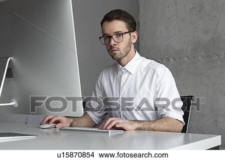 Businessman sitting at desk View Large Photo Image Picture - Businessman sitting at desk. Fotosearch
