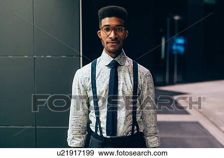 Businessman standing in front of office building View Large Photo Image Stock Photo - Businessman standing in front of office building. Fotosearch