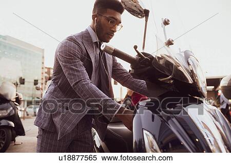 Businessman starting motorcycle on pavement View Large Photo Image Stock Photography - Businessman starting motorcycle on pavement. Fotosearch