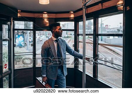 Businessman travelling on tram in city View Large Photo Image Stock Image - Businessman travelling on tram in city. Fotosearch