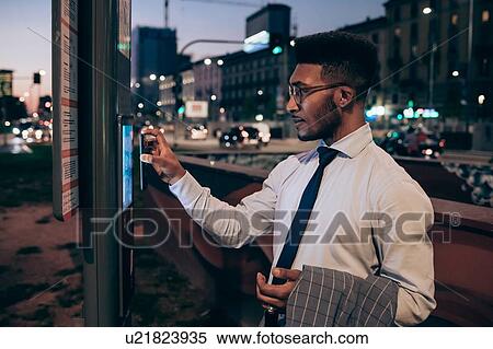 Businessman using digital information system at bus stop, Milano, Lombardia, Italy View Large Photo Image Stock Photography - Businessman using digital information system at bus stop, Milano, Lombardia, Italy. Fotosearch