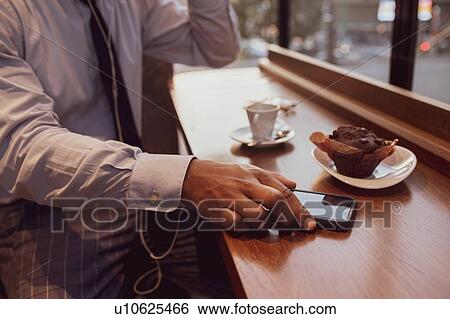 Businessman using smartphone at tea time in cafe View Large Photo Image Stock Photograph - Businessman using smartphone at tea time in cafe. Fotosearch