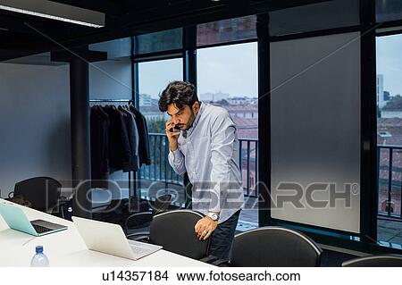 Businessman using smartphone in office View Large Photo Image Picture - Businessman using smartphone in office. Fotosearch