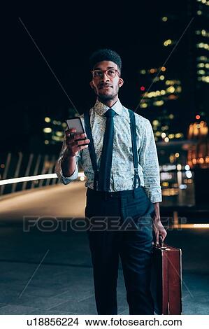 Businessman using smartphone on bridge View Large Photo Image Picture - Businessman using smartphone on bridge. Fotosearch