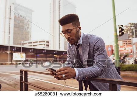 Businessman using smartphone on pavement, Milano, Lombardia, Italy View Large Photo Image Stock Image - Businessman using smartphone on pavement, Milano, Lombardia, Italy. Fotosearch