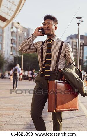 Businessman using smartphone on pavement, Milano, Lombardia, Italy View Large Photo Image Stock Photo - Businessman using smartphone on pavement, Milano, Lombardia, Italy. Fotosearch