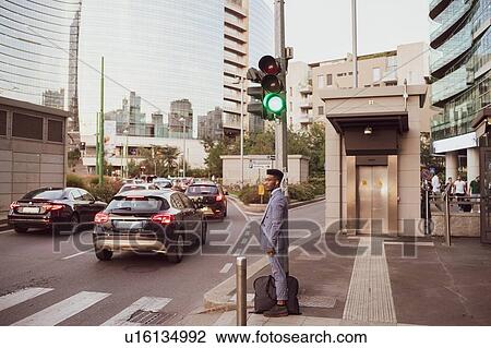 Businessman waiting by pedestrian crossing, Milano, Lombardia, Italy View Large Photo Image Stock Image - Businessman waiting by pedestrian crossing, Milano, Lombardia, Italy. Fotosearch