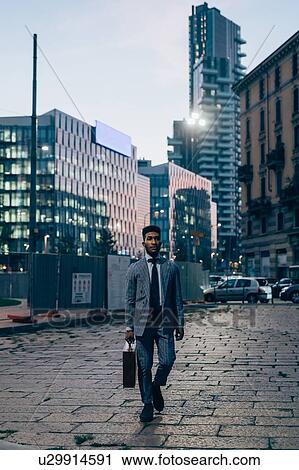 Stock Image - Businessman walking in city, Milano, Lombardia, Italy. Fotosearch