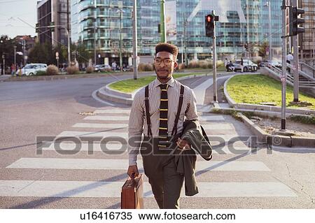 Stock Photography - Businessman walking on pedestrian crossing, Milano, Lombardia, Italy. Fotosearch
