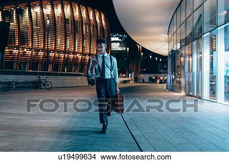 Businessman walking past buildings in city, Milano, Lombardia, Italy View Large Photo Image Picture - Businessman walking past buildings in city, Milano, Lombardia, Italy. Fotosearch