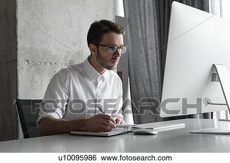 Stock Photograph - Businessman writing in notebook. Fotosearch