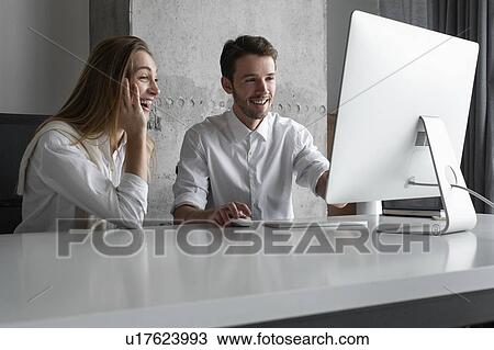 Stock Image - Businesspeople using computer together. Fotosearch