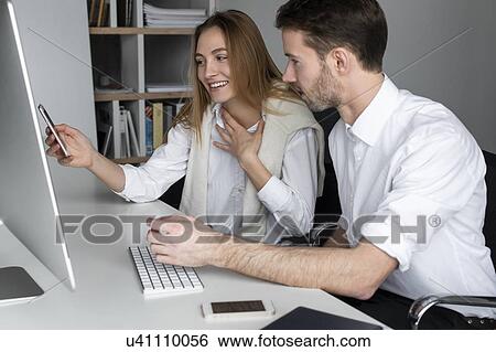 Stock Photograph - Businesspeople using computer together. Fotosearch